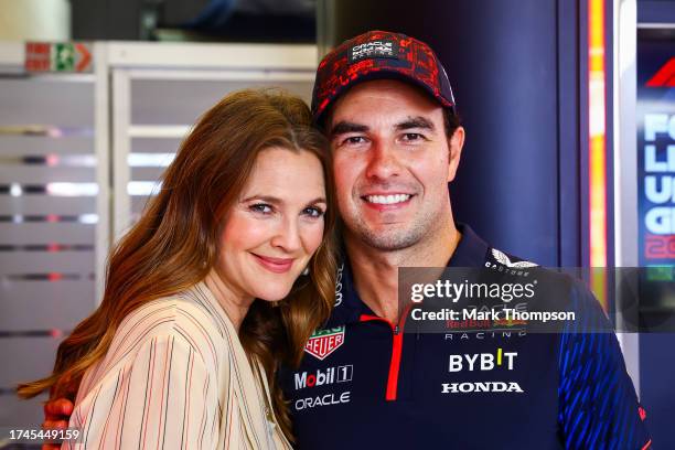 Sergio Perez of Mexico and Oracle Red Bull Racing poses for a photo with Drew Barrymore in the garage during previews ahead of the F1 Grand Prix of...