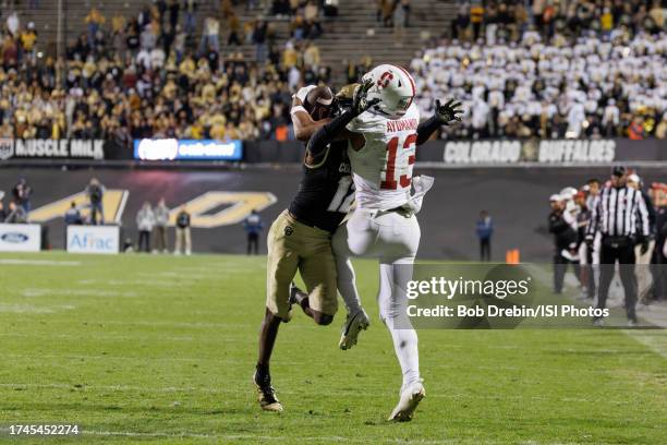 Elic Ayomanor of the Stanford Cardinal makes a 30 yard touchdown reception in the first overtime on the back of the helmet of Travis Hunter of the...