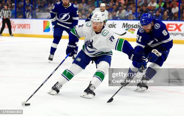 Anthony Beauvillier of the Vancouver Canucks and Erik Cernak of the Tampa Bay Lightning fight for the puck first period during a game at Amalie Arena...