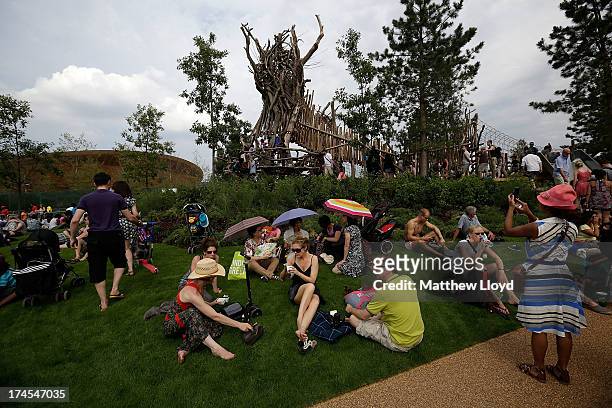 Members of the public sit on the grass as they explore the recreation facilities in the North section of the Queen Elizabeth Olympic Park during the...