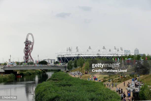 People walk towards the Olympic stadium as they explore the Queen Elizabeth Olympic Park during the Open East Festival on July 27, 2013 in London,...