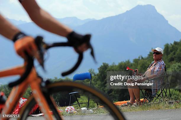 Fan sounds a horn as riders pass during stage seventeen of the 2013 Tour de France, a 32KM Individual Time Trial from Embrun to Chorges, on July 17,...