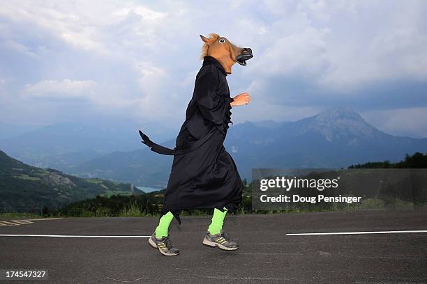 Fan in a horse costume runs down the course during stage seventeen of the 2013 Tour de France, a 32KM Individual Time Trial from Embrun to Chorges,...