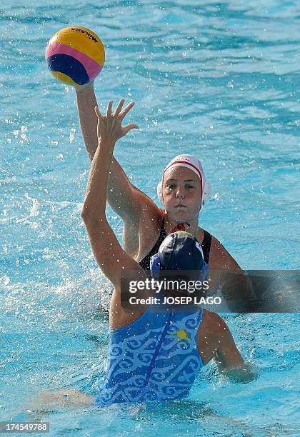 Canada's Monica Eggens is held back by Kazakhstan's Anna Zubkova during the preliminary rounds of the women's water polo at the FINA World...