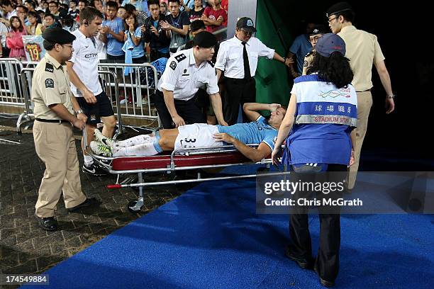 Matija Nastasic of Manchester City is taken from the field after suffering an injury during the Barclays Asia Trophy Final match between Manchester...