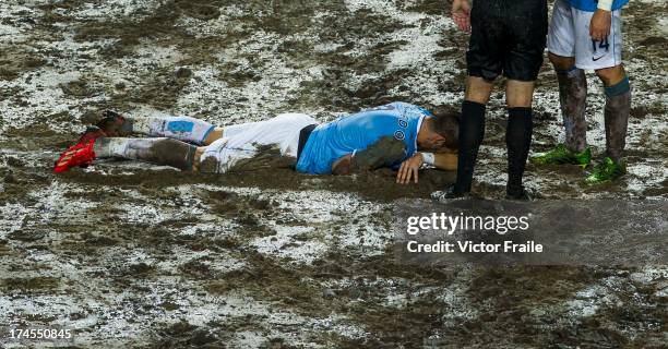 Alvaro Negredo of Manchester City lies injured on the muddy pitch after being tackled during the Barclays Asia Trophy Final match between Manchester...