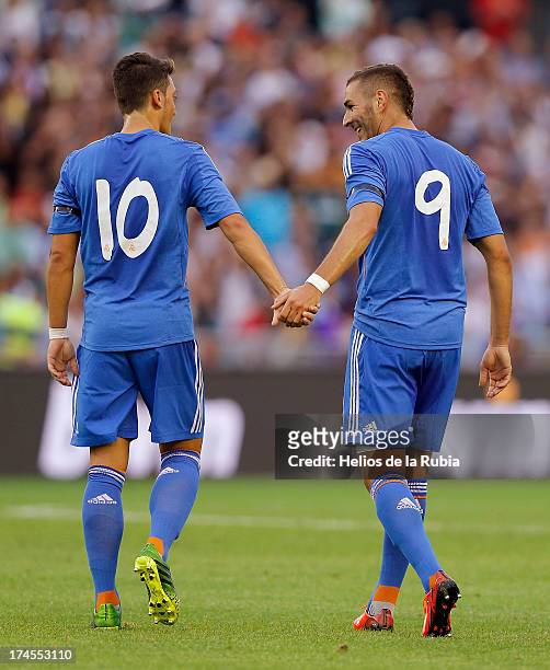 Karim Benzema and Mesut Ozil of Real Madrid celebrate after scoring during the friendly match between Paris Saint-Germain and Real Madrid at Gamla...