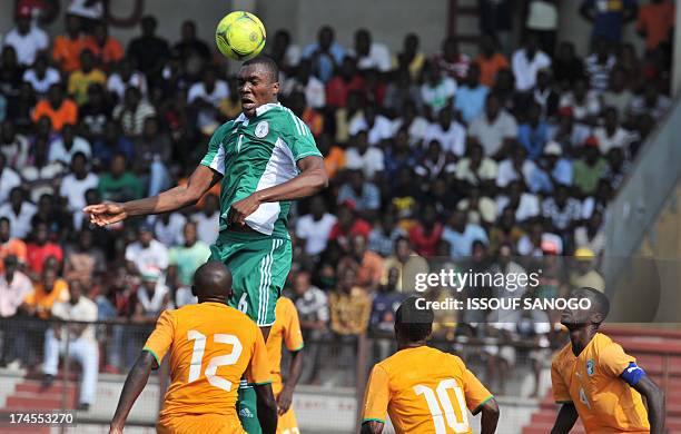 Nigerian Emmanuel Azubuike Egwuekwe vies for the the ball with Ivory Coast's players Ahmed Cheick Moukoro and Mahan Marc Goua during the 2014 African...