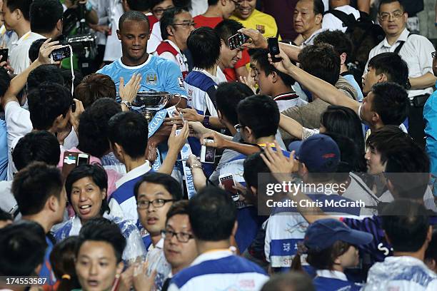 Vincent Kompany of Manchester City carries the trophy through the crowd after defeating Sunderland during the Barclays Asia Trophy Final match...