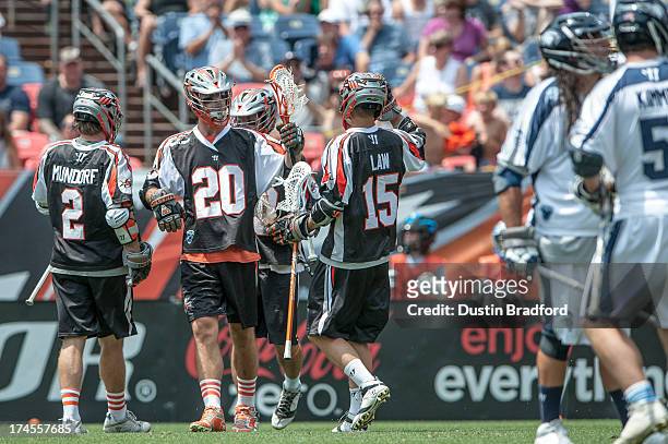 Jeremy Sieverts of the Denver Outlaws celebrates a second half goal with teammates, including Brendan Mundorf and Eric Law during a Major League...