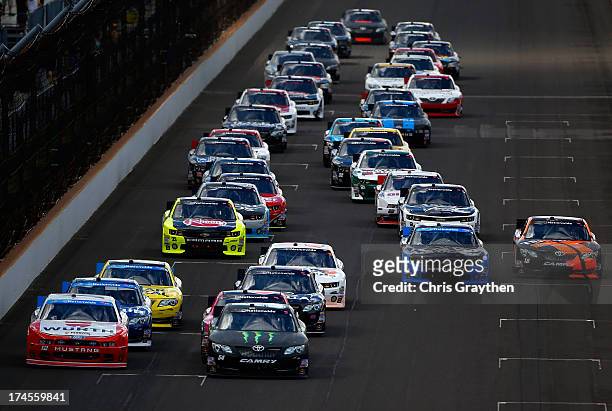 Kyle Busch, driver of the Monster Energy Toyota, and Sam Hornish Jr., driver of the Wurth Ford, lead the field towards turn one for the start of the...
