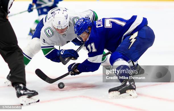 Anthony Cirelli of the Tampa Bay Lightning and Brock Boeser of the Vancouver Canucks face off in the third period during a game at Amalie Arena on...