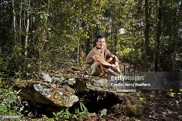 Walter Paran sits atop a dolmen on the edge of Pa Lungan village. He worries that increased logging around his town will destroy the remaining...