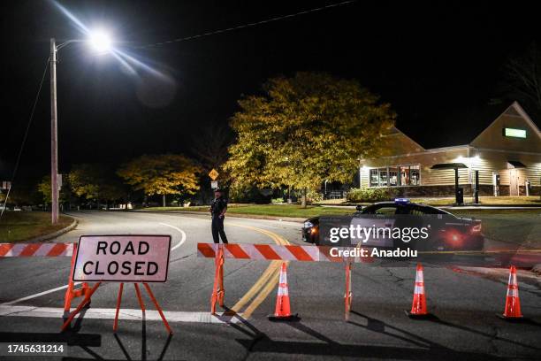 Police officers close the road as they patrol around the street during inspection after a gunman's multiple shootings in Maine, United States on...