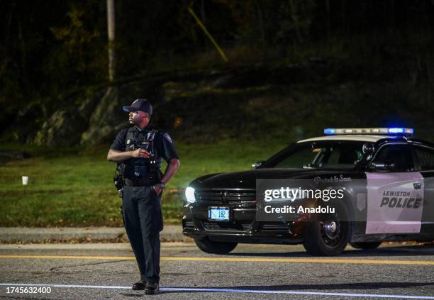 Police officers close the road as they patrol around the street during inspection after a gunman's multiple shootings in Maine, United States on...