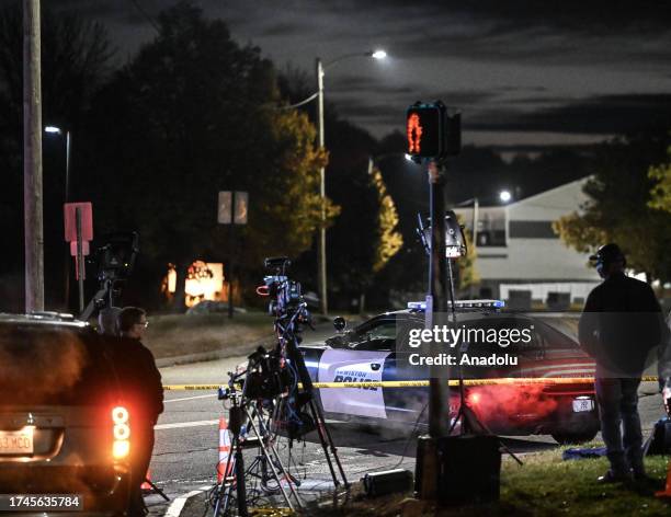 Police officers close the road as they patrol around the street during inspection after a gunman's multiple shootings in Maine, United States on...