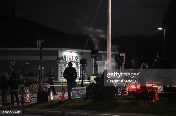 Police officers close the road as they patrol around the street during inspection after a gunman's multiple shootings in Maine, United States on...