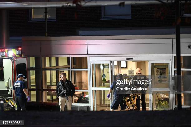 Police officers close the road as they patrol around the hospital during inspection after a gunman's multiple shootings in Maine, United States on...