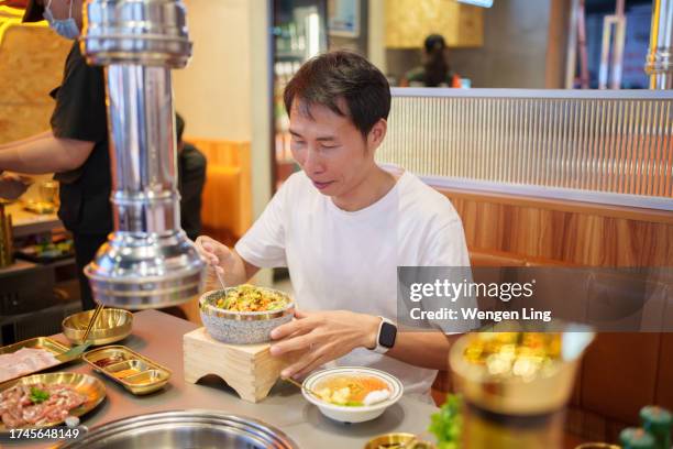 man eating korean food - korean food stock pictures, royalty-free photos & images