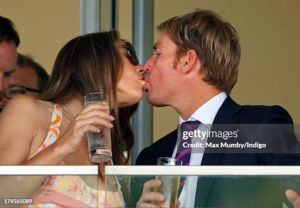 Elizabeth Hurley and Shane Warne kiss whilst watching the racing as they attend the Betfair Weekend, featuring the King George VI and Queen Elizabeth...