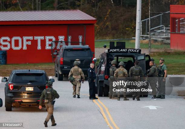 Lisbon, ME Law enforcement officials load into a tactical vehicle at Lisbon High School at daybreak as a manhunt resumes for the suspect in a mass...