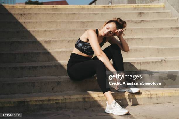 tired female athlete resting after urban workout - hyperthermia stock pictures, royalty-free photos & images