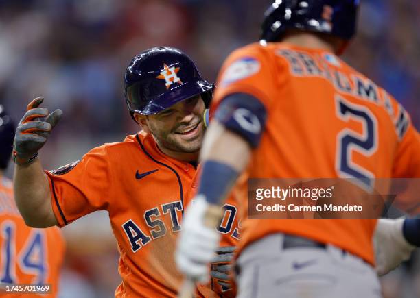 Jose Altuve and Mauricio Dubón of the Houston Astros celebrate after Altuve scored a run in the eighth inning against the Texas Rangers during Game...