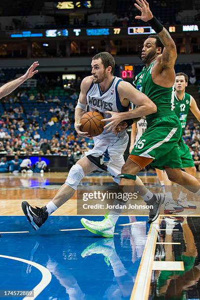 Kevin Love of the Minnesota Timberwolves drives under pressure during the preseason game between the of the Minnesota Timberwolves and the Maccabi...