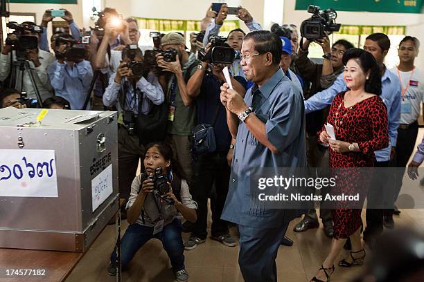 Cambodian Prime Minister Hun Sen casts his vote next to his wife Bun Rany during the Cambodian general elections on July 28, 2013 in Phnom Penh,...