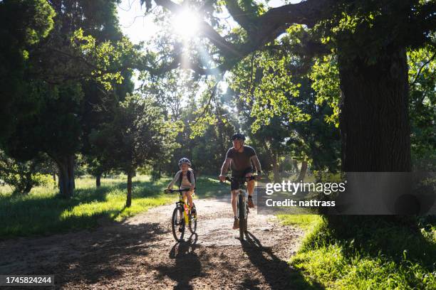 kleines mädchen radelt mit ihrem vater zur schule - bicycle daughter stock-fotos und bilder
