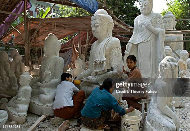 Sculptors carve Buddha images in alabaster along Mandalay streets..