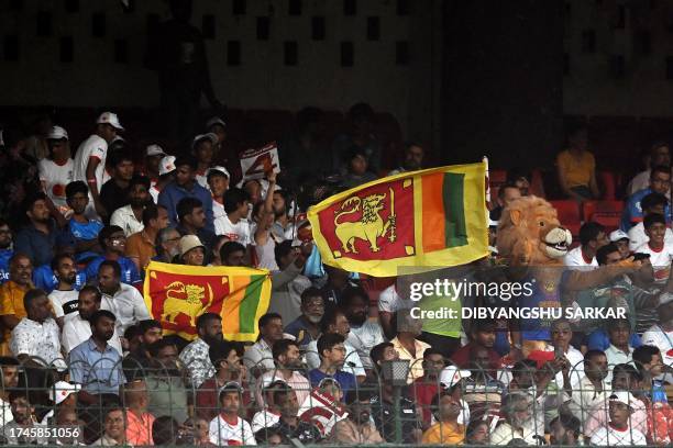 Fans hold Sri Lanka's national flags during the 2023 ICC Men's Cricket World Cup one-day international match between England and Sri Lanka at the M....