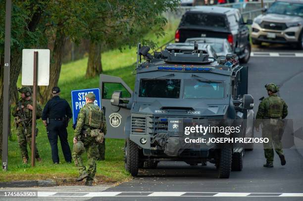 Law enforcement officers gather outside Lewiston High School, Maine on October 26, 2023. A massive manhunt was under way on October 26 for a gunman...