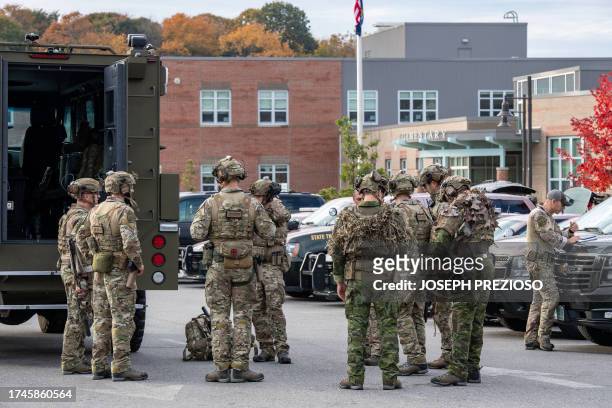 Law enforcement officers gather outside Lewiston High School, Maine on October 26, 2023. A massive manhunt was under way on October 26 for a gunman...
