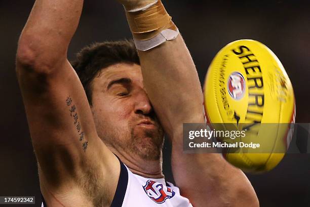 Dean Cox of the Eagles gets hit in the face by Will Minson of the Bulldogs during the round 18 AFL match between the Western Bulldogs and the West...