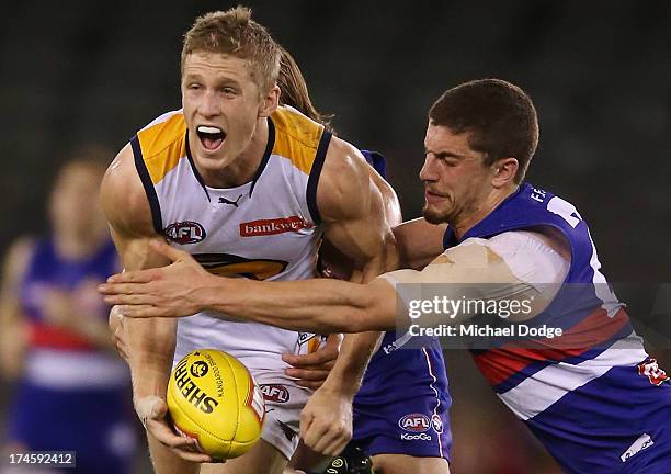 Scott Selwood of the Eagles gets tackled by Tom Liberatore of the Bulldogs during the round 18 AFL match between the Western Bulldogs and the West...