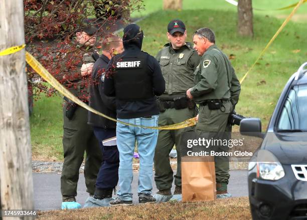 Lewiston, ME Police stand by the scene with an evidence bag in the parking lot of Schemengees Bar and Grille which was the scene of a mass shooting...