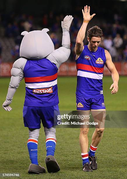 Robert Murphy of the Bulldogs celebrates the win with the Bulldogs mascot during the round 18 AFL match between the Western Bulldogs and the West...