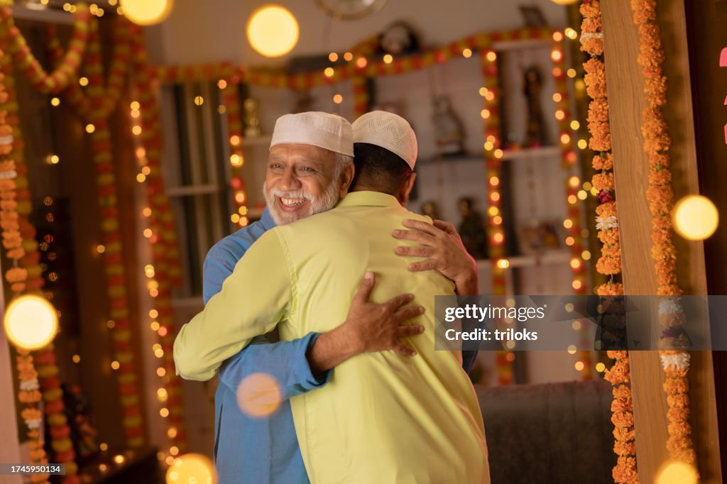 Father and son in skull caps embracing during Eid-Ul-Fitr