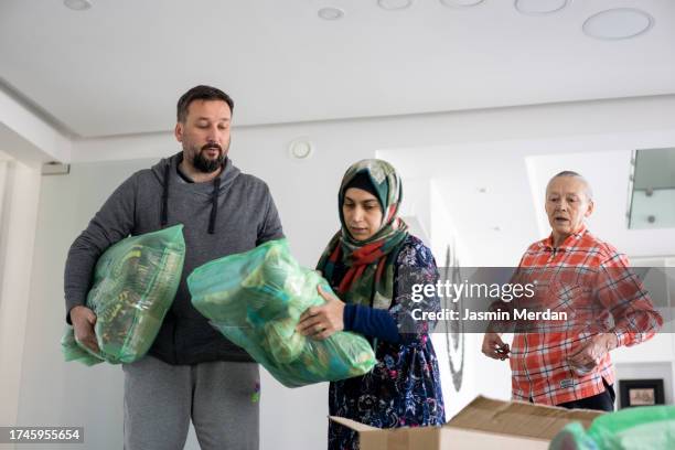 people collecting clothes for charity - man holding donation box stock pictures, royalty-free photos & images