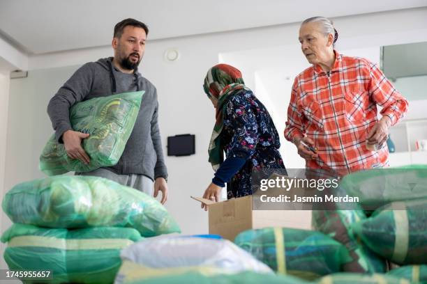 people collecting clothes for charity - man holding donation box stock pictures, royalty-free photos & images