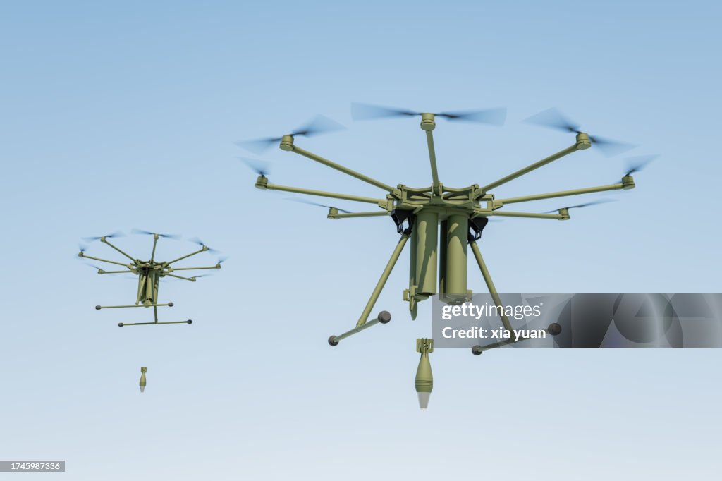 Military drone dropping bomb in blue sky