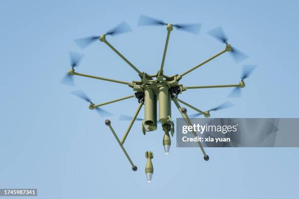 military drone dropping  bomb in blue sky - missile defense command stock pictures, royalty-free photos & images