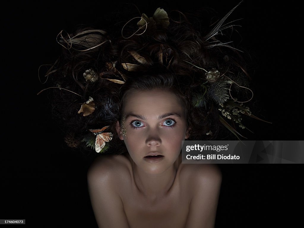 Young woman with flowers and butterfly in hair