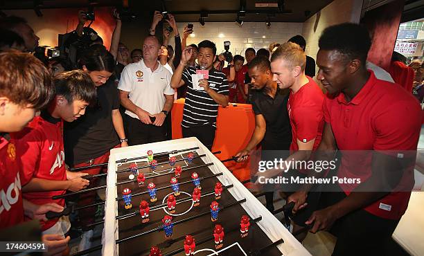 Danny Welbeck, Tom Cleverley and Patrice Evra of Manchester United FC play table football after a Q&A session at the Nike store, Mong Kok as part of...