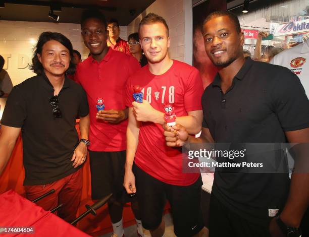 Danny Welbeck, Tom Cleverley and Patrice Evra of Manchester United FC pose with local sculptor Michael Lau and table football figures of themselves...