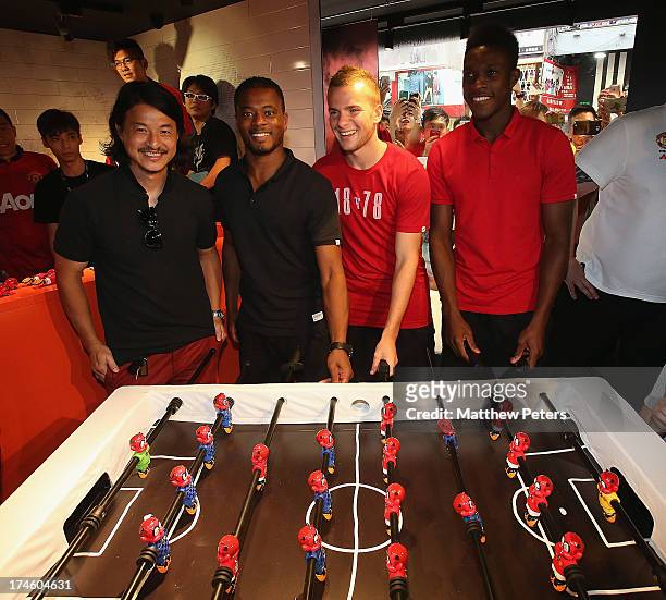 Danny Welbeck, Tom Cleverley and Patrice Evra of Manchester United FC pose with local sculptor Michael Lau after a Q&A session at the Nike store,...