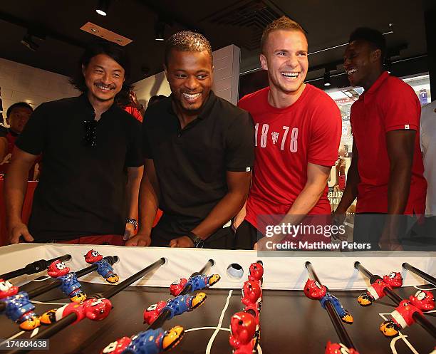 Danny Welbeck, Tom Cleverley and Patrice Evra of Manchester United FC pose with local sculptor Michael Lau after a Q&A session at the Nike store,...