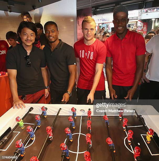 Danny Welbeck, Tom Cleverley and Patrice Evra of Manchester United FC pose with local sculptor Michael Lau after a Q&A session at the Nike store,...