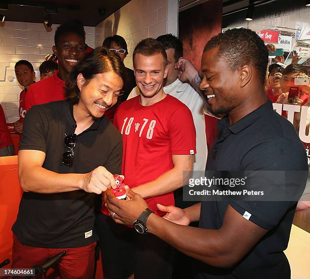 Danny Welbeck, Tom Cleverley and Patrice Evra of Manchester United FC are presented with table football figures of themselves by local sculptor...